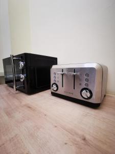 a toaster and a toaster oven on a wooden floor at Botanic Avenue Hostel less than a mile from the City Centre in Belfast