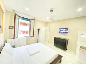 a bedroom with a white bed and a television at Moderno, tra metropolitana Milano e Aeroporto di Linate in Linate