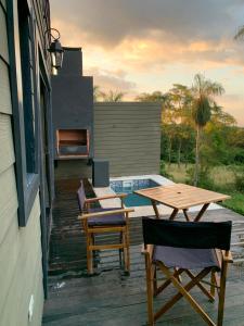 eine Terrasse mit einem Tisch und Stühlen auf einem Haus in der Unterkunft Patiño Lodge in Itauguá