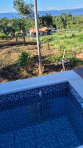 a blue tile swimming pool with a view of a field at Patiño Lodge in Itauguá