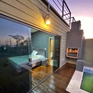 a glass house with a bed and a fireplace at Patiño Lodge in Itauguá
