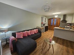 a living room with a black couch and a kitchen at Private House in Oldcastle in Oldcastle