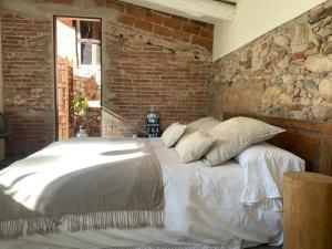 a bed in a room with a brick wall at Can TABERNER in Bigues i Riells +19 photos