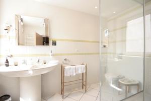 ein Badezimmer mit einem Waschbecken, einem WC und einem Spiegel in der Unterkunft Villa Rosa Trois Epis in Trois-Épis