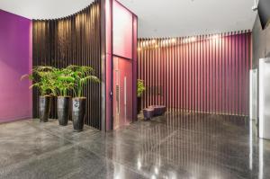een lobby met potplanten en een rode deur bij Nook Melbourne Apartments : Jane Bell Lane - Melbourne CBD in Melbourne