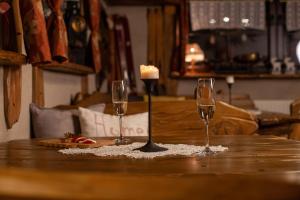 a table with two wine glasses and a candle on it at BIESIADA in Korbielów