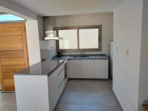 a kitchen with white cabinets and a sink and a window at Alma de Acacia Lodge in San Rafael