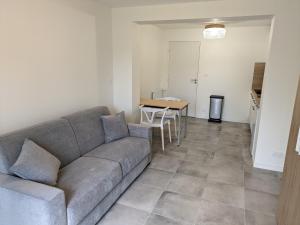 a living room with a couch and a table at Studio indépendant en rez-de-jardin in Cesson-Sévigné