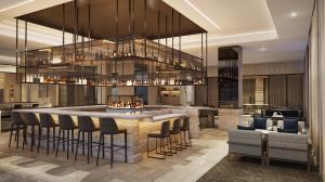 a large kitchen with a bar with stools at AC Hotel by Marriott Jacksonville St Johns Town Center in Jacksonville
