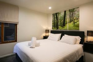 a bedroom with a large white bed with a window at Frueauf Village in Falls Creek