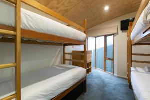 two bunk beds in a room with a balcony at Frueauf Village in Falls Creek