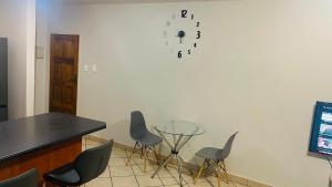 a room with chairs and a table and a clock on the wall at Damo’s Place by Mall of Africa in Midrand