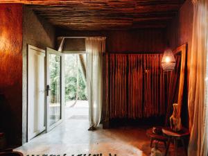 a room with a large window and a door at Nomade Tulum in Tulum