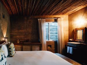 a bedroom with a bed and a window and a sink at Nomade Tulum in Tulum