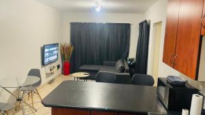 a living room with a couch and a table and chairs at Damo’s Place by Mall of Africa in Midrand