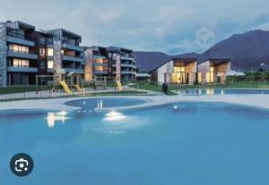 an outdoor swimming pool in front of a building at Bella casa en Costa Pucón in Pucón