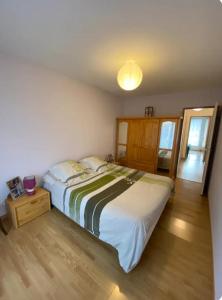 a bedroom with a large bed and a wooden floor at Appartement au cœur de Seyne in Seyne