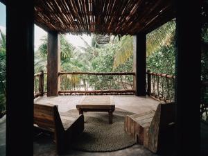 a screened in porch with a table and a bench at Nomade Tulum in Tulum