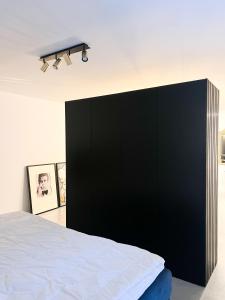 a bedroom with a black headboard and a black wall at Suite One Einsteinstraße in Munich