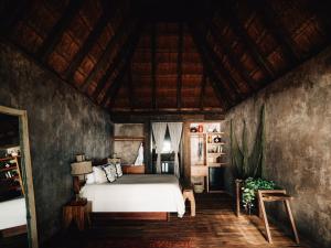 a bedroom with a bed and a wooden ceiling at Nomade Tulum in Tulum