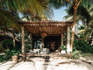 a resort with a bed and palm trees at Nomade Tulum in Tulum