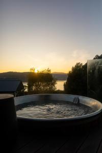a hot tub with the sunset in the background at Woodland Bay Retreat-Luxury Hamptons Retreat in Lymington