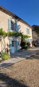 a building with a blue door and a bench outside at Raisin et Toile - French American Retreat in La Rochebeaucourt-et-Argentine