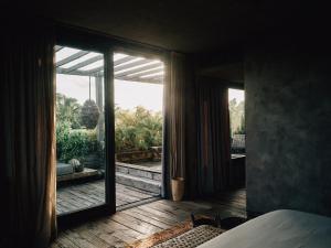 a bedroom with a large glass door leading to a patio at Nomade Tulum in Tulum