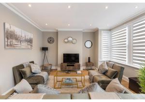 a living room with two couches and a tv at Chic & Radiant Retreat in Harringay Ladder in London