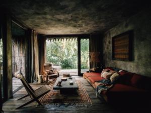 a living room with a couch and a large window at Nomade Tulum in Tulum