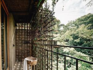 a balcony with a view of a forest at Nomade Tulum in Tulum