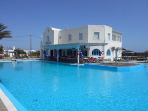 a large blue swimming pool in front of a building at The Three Anchors Rooms in Emboríon