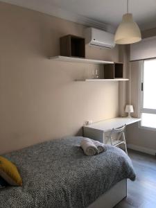 a bedroom with a bed and a desk and a window at Apartamento Parquesol in Antequera