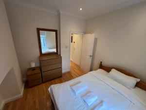 a bedroom with a large bed and a mirror at Flat in London King’s Cross in London
