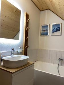 a bathroom with a sink and a tub and a mirror at Chata pod horou in Stará Lesná