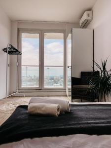 a bedroom with a bed with a large window at Highrise Horizon Penthouse in Budapest