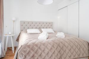 a bedroom with a bed with towels on it at Guestly Homes - 1BR Harbor View Suite in Piteå
