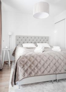 a white bedroom with a large bed with a white wall at Guestly Homes - 1BR Harbor View Suite in Piteå
