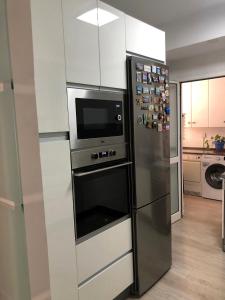 a kitchen with a stainless steel refrigerator with a microwave at Apartamento Parquesol in Antequera