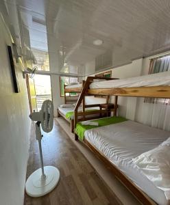 Schlafsaal mit 2 Etagenbetten und einem Ventilator in der Unterkunft Raw KokoMar PosadaNativa in Barú