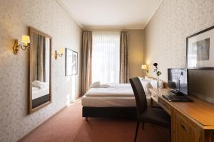 Pokój hotelowy z łóżkiem i biurkiem w obiekcie Grand Hotel Beau Rivage Interlaken w mieście Interlaken