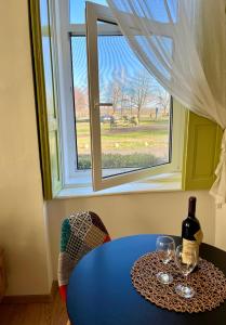 a blue table with wine glasses and a window at OLD TISA Apartment in Senta