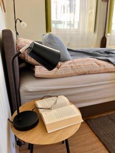 - un bureau avec une lampe et un livre sur une table avec un lit dans l'établissement OLD TISA Apartment, à Senta