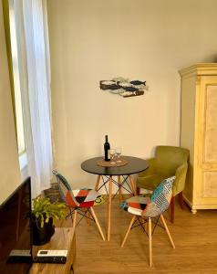 a table with chairs and a bottle of wine on it at OLD TISA Apartment in Senta