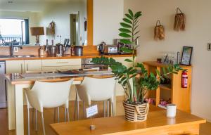 The Retreat - Luxury Hillside villa at Te Ngaere Bay في Kaeo: مطبخ مع طاولة عليها نبات