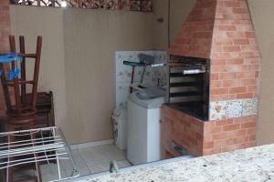a kitchen with a brick oven with a trash can at Casa Itapema/SC pertinho do mar! in Itapema