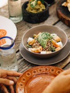 a bowl of food on a table with a plate of food at Nomade Tulum in Tulum