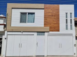 a house with two white garage doors and a window at Durango Life in Durango
