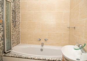 a bathroom with a tub and a sink at A hidden Gem in the heart of Dagenham! in Goodmayes