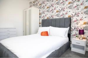 een slaapkamer met een bed en bloemenbehang bij A hidden Gem in the heart of Dagenham! in Goodmayes